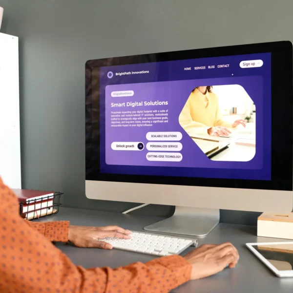 Side view of smiling African American woman using PC computer with Smart digital solutions website sitting at workplace in office copy space